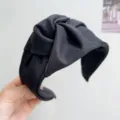 Primer plano de una diadema ancha de tela negra con diseño de nudo y textura suave. - Estilo de Nudo Ancho / Negro