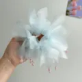 Primo piano di un elastico in organza azzurro con delicati ciondoli in cristallo rosa. - Blu + Rete Bocciolo Elastico