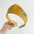Detailed macro view of a vintage yellow textured faux leather headband with silver metal rings - Crown Leather Ring Style / Yellow