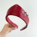 Primo piano dettagliato della fascia in pelle rossa testurizzata con anelli d'argento. - Stile Corona e Anello in Pelle / Rosso