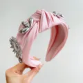 Detailed view of a pink satin knotted wide headband decorated with silver metallic flowers - 金属花挂件打结发箍 / Black