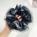 Macro detail view of a black floral scrunchie featuring elegant pleated mesh edges in hand - Black With Polka Dot Floral Mesh Edge