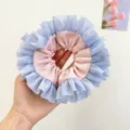 Detailed close-up of ballet style pink and blue ruffled lace hair scrunchie for women - Pink + Blue