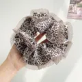 Close-up detail of oversized leopard print scrunchie with elegant pleated lace edges - Off-White Leopard With Mesh Edge