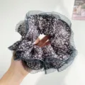 Close-up of a leopard print scrunchie with mesh ruffle trim - Light Purple Leopard With Mesh Edge