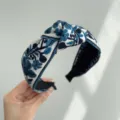 Primer plano de una diadema bohemia con bordado de flores azules y detalle de nudo. - Floral Azul (Diadema Anudada)