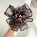 Gros plan d'un chouchou en maille léopard avec une texture froncée élégante - Chouchou Mince Plissé / Imprimé léopard café