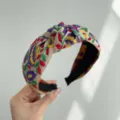 Primer plano de una diadema bohemia con bordado floral vibrante y diseño anudado. - Floral Púrpura Arroz (Diadema Anudada)