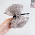 Detalle de una pinza para el pelo con lazo de malla de leopardo y centro de strass. - Pinza de Lazo / Estampado de leopardo beige