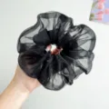 Detailansicht eines großen schwarzen Organza-Haargummis mit schimmernder Textur - Netz-Haargummi / Schwarz