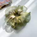 Detailansicht eines schimmernden hellgrünen Haargummis aus Organza mit Glanzeffekt. - Netz-Haargummi / Grün