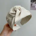 Detalle de una elegante diadema de tela color crema con diseño de nudo superior. - Estilo de Nudo Ancho / Beige