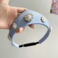 Nahaufnahme eines hellblauen Satin-Haarreifs mit eleganten Perlenblumen-Verzierungen. - Verdickter Kronenstil / Blau