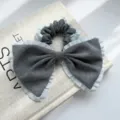 Detailansicht eines grauen Haargummis mit blauer Spitze und großer Schleife für Damen - Haargummi / Schleife Plissierter Rand Scrunchie