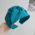 Detalle de una diadema de tela azul turquesa con diseño de nudo y textura de canalé. - Estilo de Nudo Ancho / Verde azulado