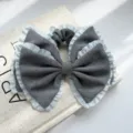 Nahaufnahme eines großen grauen Haargummis mit hellblauen Rüschen und Schleife - Doppelschleife Plissierter Rand Scrunchie