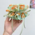Macro detail view of a soft green floral print scrunchie with an elegant ribbon bow. - Bow Streamer Style / Green