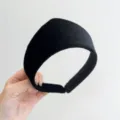 A detailed close-up shot of a wide black velvet padded headband in a vintage style. - Black