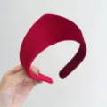 Detailed close-up shot of a luxurious retro padded red velvet headband with soft texture - Dark Red