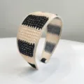 Détail en gros plan du serre-tête en paille tressée noir et beige à texture fine - Noir Beige