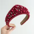 Primo piano di un cerchietto corona rosso retrò decorato con eleganti perle e strass luccicanti - Cerchietto Perle Strass / Rosso