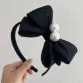 Detailansicht eines eleganten schwarzen Stoff-Schleifen-Stirnbands mit zwei großen weißen Perlen - 3-lagiges Bogen-Perlen-Haarband / Schwarz