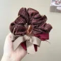 Close-up of a plaid scrunchie with a dual-color ribbon bow and elegant gold piping. - L / Wine Red Plaid Bow Hair Tie