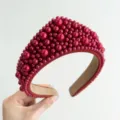 Vue macro d'un serre-tête rouge de luxe rembourré avec des perles brillantes - Perle / Rouge