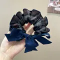Detailed close-up showing the plaid fabric and navy blue bow of this stylish hair scrunchie - L / Dark Blue Plaid Bow Hair Tie