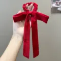 Close-up of an elegant red velvet bow hair tie with long ribbons for hair styling - Bow Streamer Style / Red