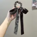 Close-up of elegant gray velvet bow ribbon scrunchie hair tie for women's autumn hair style - Bow Streamer Style / Brown