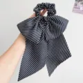 Detailansicht eines Vintage Haargummis mit schwarz-weiß gestreifter Schleife und Bändern - Schleife Band Haargummi / Schwarz-weiße Streifen