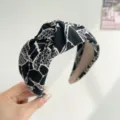 Close-up of black and white ink wash floral pattern on a knotted wide headband. - Ink Print Knot Style / Black