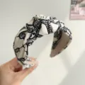 Detailed close-up view of a wide knotted ink floral headband with black lace-style pattern. - Ink Print Knot Style / White