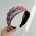 Close-up detail of a bohemian ethnic embroidered wide headband in light blue fabric - Wide Headband / Blue Orange