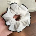 Detailansicht eines weißen Samt-Haargummis mit funkelnder schwarzer Kristallperlenkante. - Großer Samt Strass Stil (S746) / Weiß
