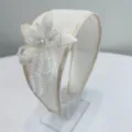 Detailed view of handmade beaded flower embellishment on a elegant white wide headband. - Off-White (S729)