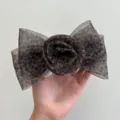 Détail précis d'une pince à cheveux élégante avec rose en résille et nœud léopard. - Pinces à ressort / Imprimé Léopard Avec Rose Et Nœud