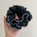 Detalle de un coletero de organza negro con bordes de volantes en color azul claro. - Coletero a Capas / Azul Negro