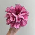 Primer plano de un coletero rosa grande con volantes y costuras de borde lavanda - Coletero a Capas / Rosa