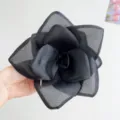Detailed macro view showing the texture of an oversized black mesh rose hair clip - Black