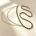Chaîne de taille tressée en métal doré et cuir noir, accessoire élégant pour robe ou costume. - Chaîne de Taille Tissée Dorée avec Pendentif Point Style Glands