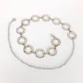 Silberne Metall-Taillenkette mit strukturierten Rundgliedern und verstellbarer Kette. - Ringmünze / Silber