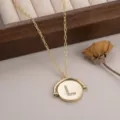 Gros plan macro d'un pendentif en or circulaire rotatif avec la lettre L sertie de cristaux fins - 镶钻字母L款