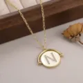 Détail rapproché d'un pendentif doré pivotant orné d'une lettre N sertie de strass - 镶钻字母N款
