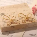 Detailed macro view of golden geometric butterfly bow earrings with size and weight markers - Matte Gold Bowknot Stud Style (2-27164-5500)