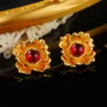Close-up of vintage golden flower earrings with a red center stone for elegant style - Ruby Look Gem Layered Petal Style (E4-19428A-5600)