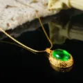 Detail shot of vintage gold necklace with oval green stone on reflective surface - Necklace Pendant / Emerald Cabochon (E4-1100G-N-5500)
