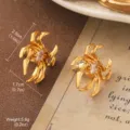 Close-up detail of vintage gold-toned spider-shaped stud earrings with crystal center - Golden Radial Claw Style (2-26175-4900)