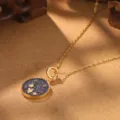 Detailed view of vintage gold necklace with floral enamel pendant and warm lighting - Plum Blossom Zodiac Flower Necklace (2-27219-N-6500)